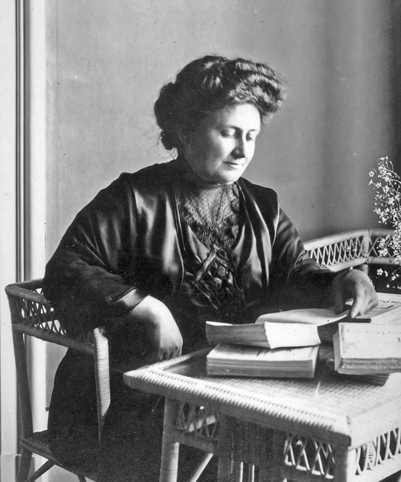 Maria Montessori in ein Buch vertieft